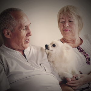 An older couple holding a dog