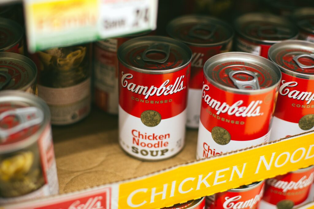 Image of a cardboard box filled with cans of Campbell's chicken noodle soup.