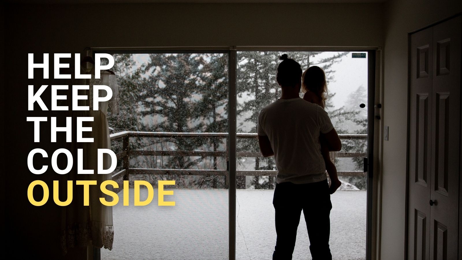 A father holds his daughter in a dark room as snow falls outside. Block text reads: 